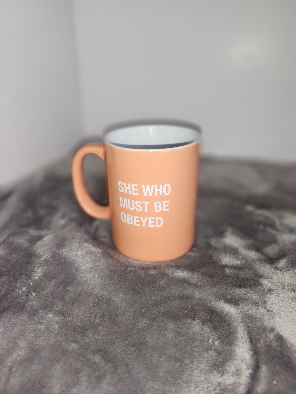 Peach-colored coffee mug by About Face Designs